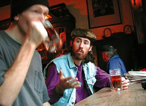 The guy (right) discusses Stevie Ray Vaughan with an uninterested stranger.